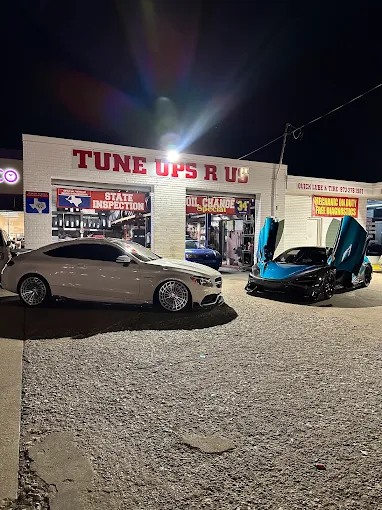 Mercedes coupe and a McLaren parked outside the shop at night
